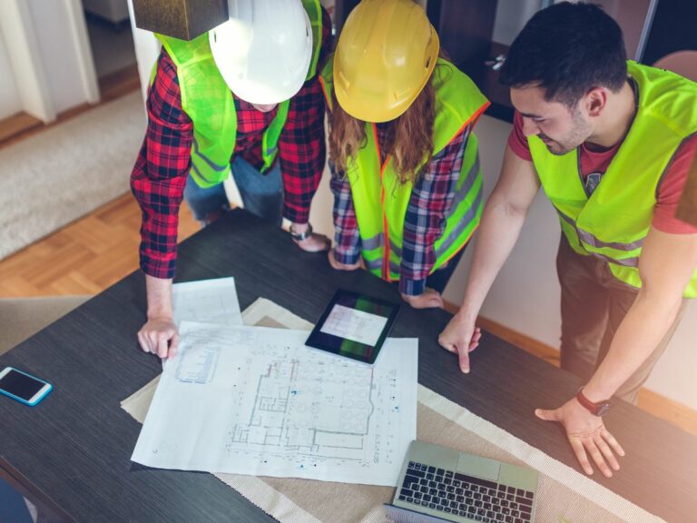 Learn how to hire the right contractor. Contractors and planners viewing an architectural rendering.