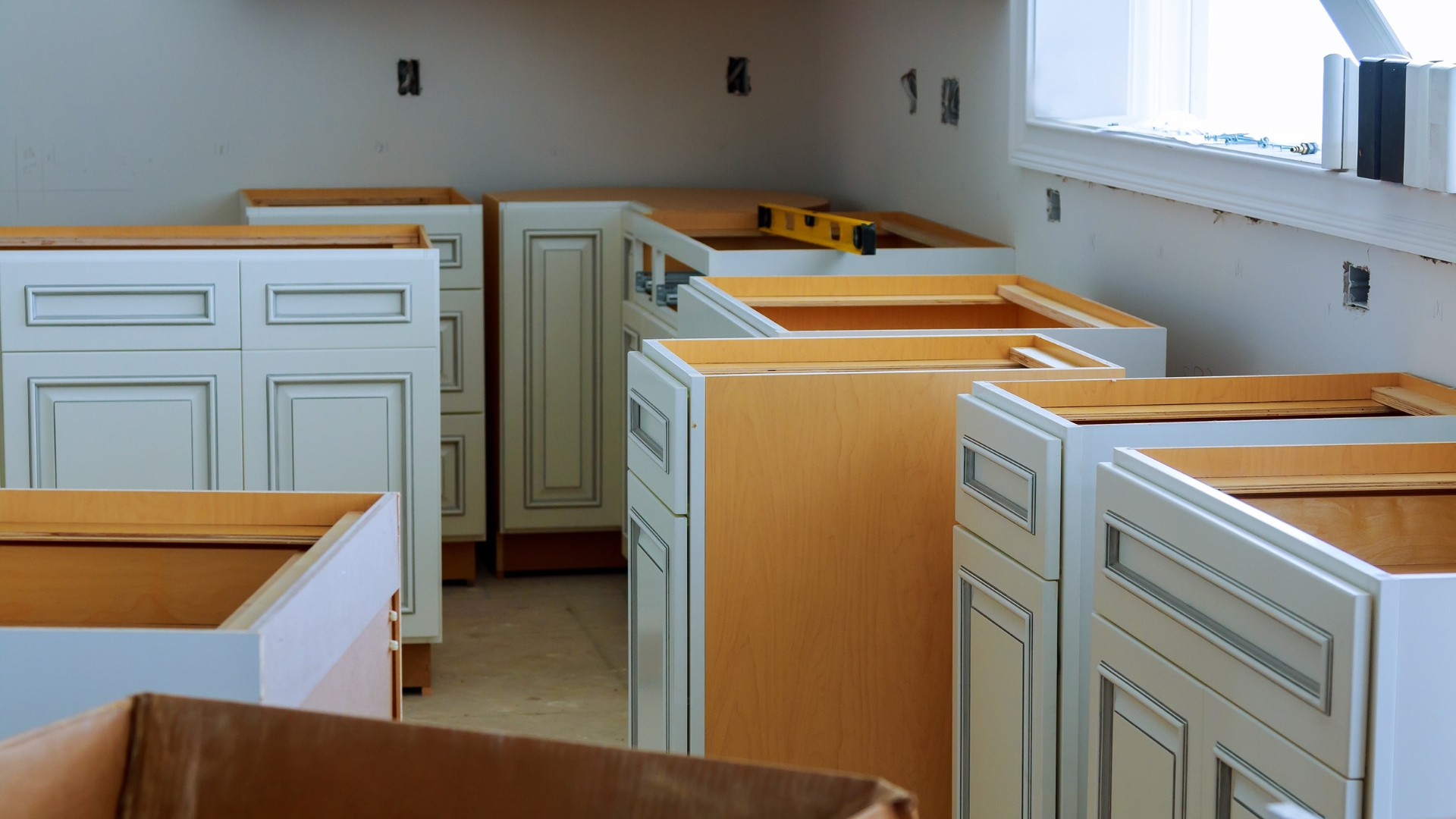 A picture of cabinets being installed in a kitchen.